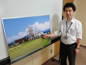木質バイオマス発電設備の完成予想図を示す佐久間英明さん。電気は２０年間、固定価格で売電される＝神戸市中央区脇浜町１、神鋼環境ソリューション本社