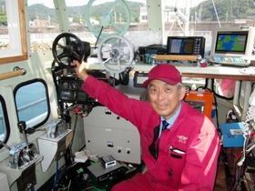 漁船を改造したプラグインハイブリッド船の内部。南繁行さんが持つ黒いハンドルは電動モーター用の操舵（そうだ）輪＝南あわじ市