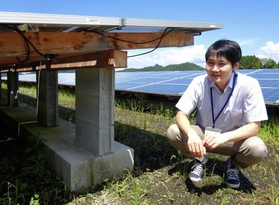 太陽光パネルの木製架台を説明する篠倉崇泰さん。パネルが屋根となり、雨から木を守る構造にしている＝佐用町