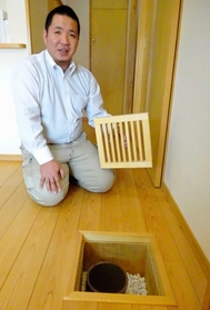 夏は涼しく、冬は暖かい空気が吹き出し口から出る。「天候に左右されないところも地中熱のいいところ」と話す高見淳さん＝丹波市春日町