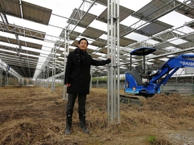 太陽光の半分を発電に、半分を農業に使うように農地の上空にパネルを並べたソーラーシェアリング施設を説明する五角哲司さん＝三木市別所町小林