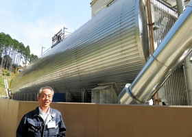 ごみの有機物を発酵させてバイオガスを発生させる装置について説明する高岡好和さん＝朝来市和田山町高田