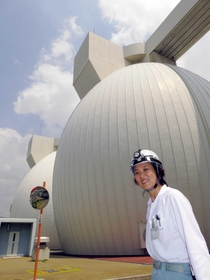 下水汚泥とスイーツなどを発酵させる消化タンクを説明する児玉さん＝神戸市東灘区、東灘処理場