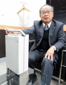 昨年完成させた、軽量で持ち運びと連結が可能な電池パックを説明する雨堤さん＝洲本市五色町
