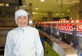 ヒートポンプで冷却された日本酒製品の近くに立つ柴田秀昭さん＝神戸市東灘区魚崎浜町、灘魚崎工場