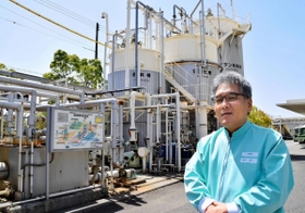 食品廃棄物からバイオガスを発生させる装置の前で説明する岸戸伸一さん＝神戸市東灘区向洋町西２