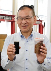 インフィオラータで使った花びらを乾燥させた原料（右）と、完成したバイオコークス（左）を手にする井田民男さん＝大阪府東大阪市、近畿大学