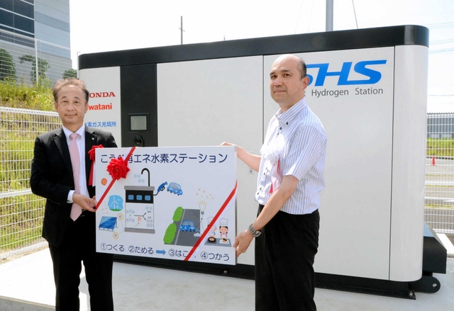 説明パネルを手に完成を喜ぶ関係者＝こうべ環境未来館