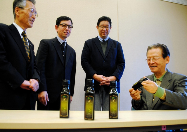 搾油機導入を目指す「淡路島オリーヴ協会」の土居政廣理事長（右）ら＝洲本市文化体育館