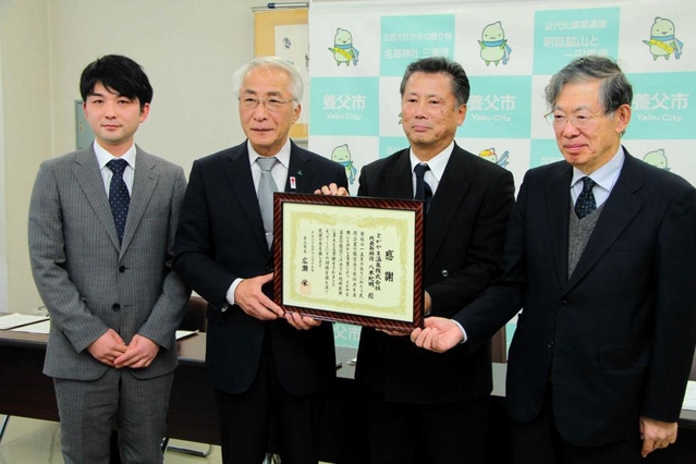 検証報告会で感謝状を受け取るキタイ設計の八木紀明常務（右から２人目）＝養父市八鹿町八鹿、八鹿公民館