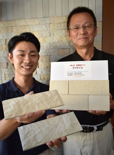 竜山石の機能性を生かした「タツタイル」を手にするケープランの岸本和樹社長（右）と憲征統括部長＝加古川市野口町北野