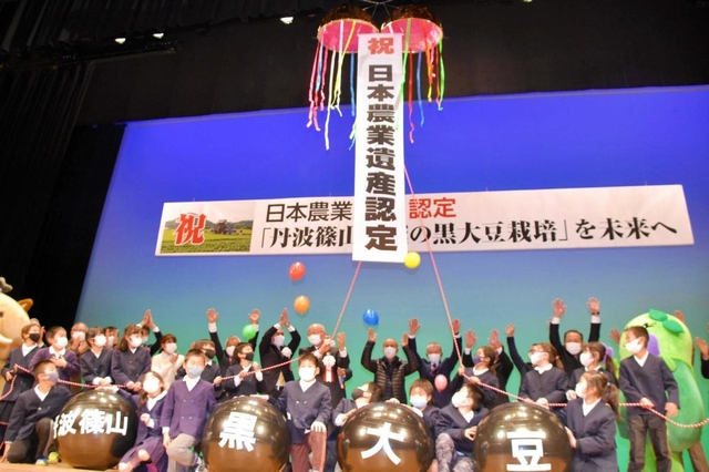 祝賀セレモニーでくす玉を割り、喜びを分かち合う参加者ら＝田園交響ホール
