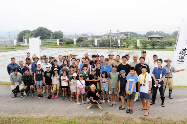 田植え後に記念撮影に納まる宮坂醸造社員と農家、住民ら＝加東市山国