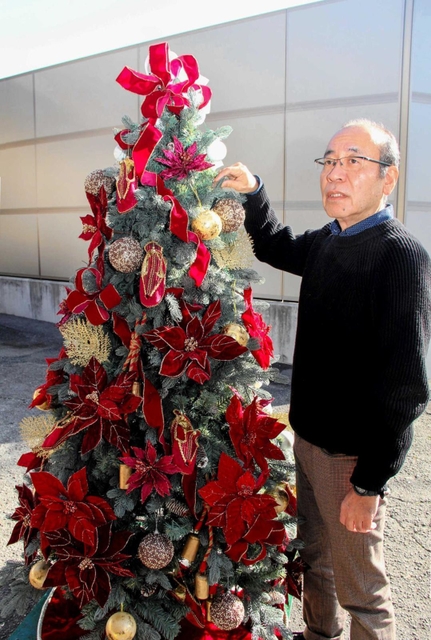 クリスマスを彩るツリーを前に、会社の歩みを語る中城産業の中城秀蔵社長＝姫路市城東町