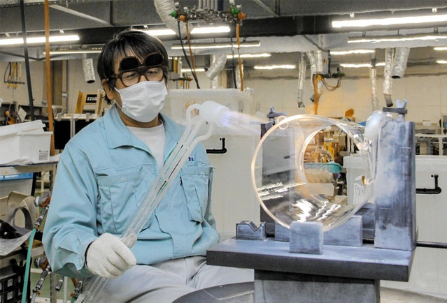 石英ガラスを加工する社員。約２千度の熱を当てる＝姫路市夢前町杉之内