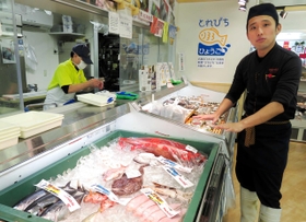兵庫各地から届いた魚について説明する店長の山形高広さん（右）＝三田市川除、パスカルさんだ一番館