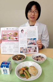 芦屋の給食の冊子について話す奥さん。この日の給食は淡路産鶏ひき肉のつくねや篠山市産小豆の赤飯など＝芦屋市立精道小学校