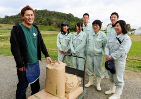播磨農業高校生たちが作った米を受け取る北原拓将さん（左）＝加西市北条町東高室