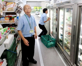 車内で８００種類の商品の買い物ができる特注の移動販売車について説明する田原吉美さん＝豊岡市日高町、ガンピー穀物倉庫