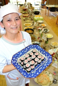 丹波黒大豆入りの黒豆ずしを手にする岡部祐美さん。多彩な料理は毎朝出勤後に調理する＝篠山市下坂井