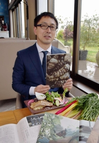 「兵庫食べる通信」を手にする編集長の光岡大介さん＝西宮市高松町、「野菜ビストロ　レギューム」