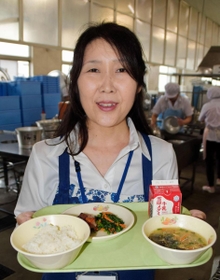 稲美町産のコメや小松菜、みそなどを使った給食を手にする佐用ヱリカさん＝稲美町立天満小学校