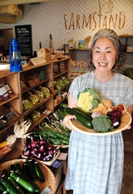 神戸産の野菜に囲まれる小泉亜由美さん＝神戸市中央区山本通１、ファームスタンド
