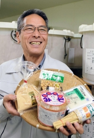 佐用もち大豆で作ったみそや煮豆を手にする小林信次さん＝兵庫県佐用町福吉、ふれあいの里上月