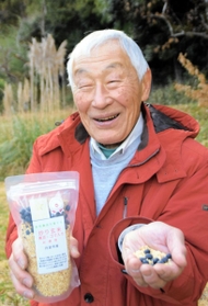 丹波市産の玄米や黒豆などを焙煎加工した商品を手にする宇津江忠夫さん＝丹波市春日町山田