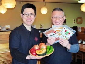 地元の野菜たっぷりの冷凍カレーを手にする辻田誠さん（右）と営業を担当する長男の貴大さん＝川西市西多田、麺工房梵天
