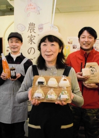 昨年１０月に発売した「神戸米おにぎり」を手にする山田三千代さん（中央）とコメ農家の小池潤さん（右）ら＝神戸市灘区倉石通３、農カフェ「ちょっとの幸せ、おすそわけ。」