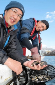 手頃な大きさに育ったマガキを手にする伊保漁協の大西正起さん（左）と同漁協の奥虎二郎さん＝高砂市沖