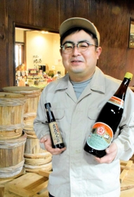 地域で長く親しまれる「濃口醤油」（右）と江戸時代の製法で造る「古式丸大豆しょうゆ」を手にする高橋伸弥社長＝加西市和泉町、高橋醤油