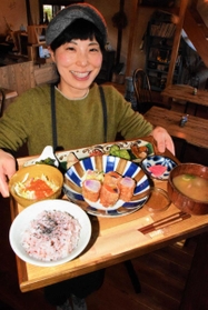夫が育てた有機無農薬の野菜をふんだんに使ったランチを手にする牛尾祐美子さん＝兵庫県福崎町山崎、「農家のごはん　ことほぎ」