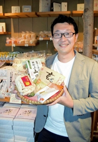 「山田錦せんべい」や「玄米このは」などの商品を手にする有元誠次朗さん＝加西市常吉町、アリモト加西工場