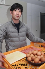 自慢の卵、卵白や卵黄の冷凍パックをのせたトレーを持つ山口洋史社長＝丹波市春日町栢野