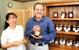 瓶詰めのハチミツを手にする稲田慎二さん（右）と、結花さん＝神戸市北区鈴蘭台西町５、いなだ養蜂園