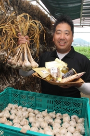 ニンニク「ハリマ王」や加工した商品をＰＲする北本奇世司さん＝加西市東剣坂町
