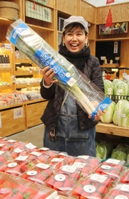 入荷したイチゴを前に北神ねぎを手にする武田愛さん＝神戸市北区大沢町上大沢