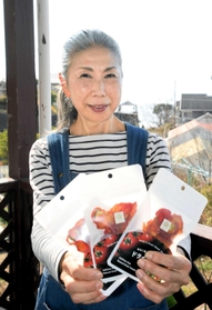 夫と２人で開発したドライトマトを手にする三谷久美子さん＝淡路市野島江崎
