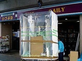 店頭に設置するために搬入されるコイン精米機（２００６年５月撮影、いづよね提供）