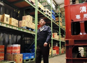 酒類の倉庫内を見回る内海淳社長。かつて商品を棚から出し入れするアルバイトで汗を流した場所だ＝姫路市飾磨区（撮影・大森　武）