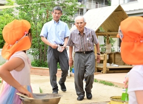 園児たちに話しかける梅村貞造さん（右）と長男の新さん。親子二代の園長だ＝西宮市高木東町（撮影・中西幸大）