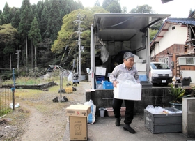 コープこうべが週１回届ける協同購入の商品を運ぶ女性。組合員とのおしゃべりも楽しみの一つだ＝兵庫県香美町小代区神場