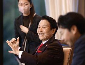 社員に囲まれ「雇用創造の夢」を語る南部靖之氏＝淡路市野島常盤、グローバルハブスクエア