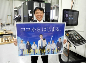 ドラマ「下町ロケット」の番組宣伝を模したパネルを持つ佐藤慎介さん＝たつの市揖西町土師、佐藤精機たつのテクニカルセンター