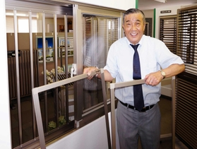 網戸を２枚組み込んだアイデア商品「アミダーブル」の網戸を外す中村孝社長＝尼崎市長洲本通１、ナカムラ