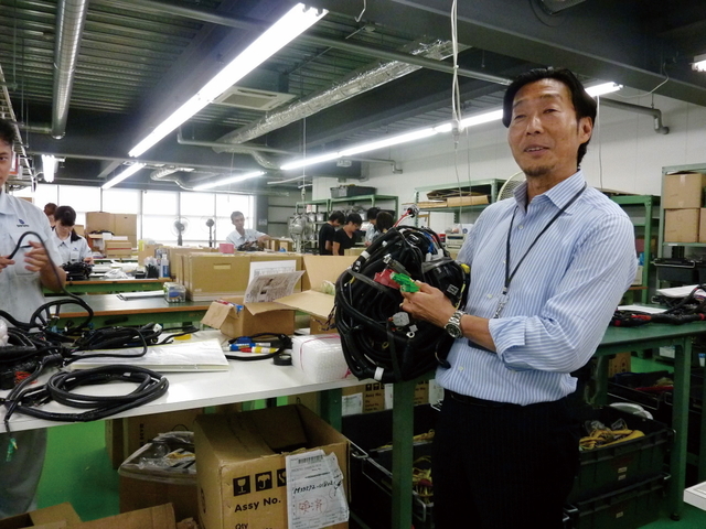 ワイヤハーネスを手に企業理念などを話す米田昭彦社長