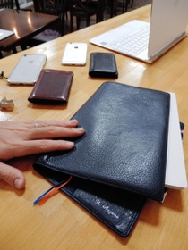 手になじんだネーム入りの手帳カバーなど、青山さんのかばんの中身。スマートフォンと名刺入れは会社と副業用の二つ。ノートパソコンで顧問先とウェブ会議もする＝神戸市中央区北野町１、ｐｌｕｇ０７８