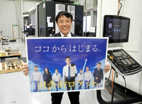 テレビドラマ「下町ロケット」の番組宣伝を模したパネルを持つ佐藤慎介さん。たゆまぬ技術向上で「播磨からロケット品質を生み出したい」＝たつの市